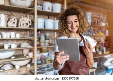 Female potter with tablet computer in art studio  - Powered by Shutterstock