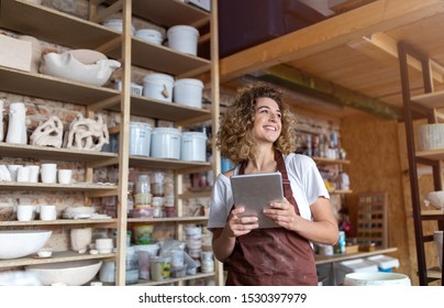 Female potter with tablet computer in art studio  - Powered by Shutterstock