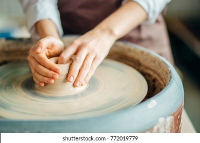 Female potter working at throwing wheel at studio. Clay workshop - Powered by Shutterstock