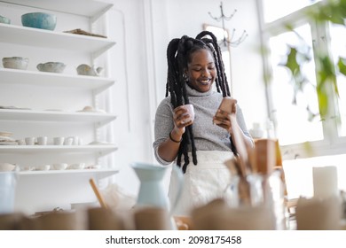 Female pottery artist using smartphone in her art studio 
 - Powered by Shutterstock