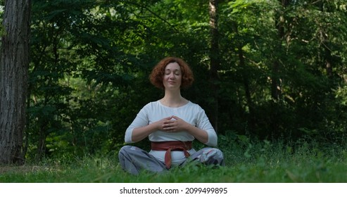 Weibliche, die im Sommerpark oder im Wald Golf und Meditation praktizieren