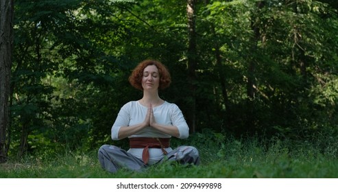 Weibliche, die im Sommerpark oder im Wald Golf und Meditation praktizieren
