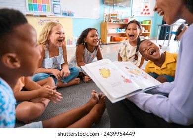 Female Primary Or Elementary School Teacher Reads Story To Multi-Cultural Class Seated In Classroom - Powered by Shutterstock