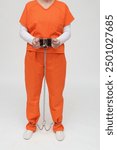 female prisoners in handcuffs and leg irons and orange overalls with fuse box