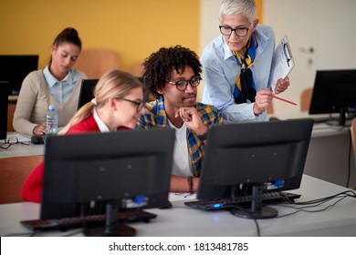 Female professor helping students at an informatics lecture in the university computer room