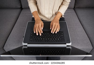 Female programmer coding on laptop at home. Woman typing text on notebook pc keyboard