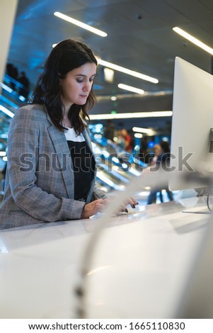 Female programmer or computer administrator working behind computer. Young woman behind a desk with several computers and screens, repairing and installing new hardware