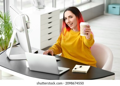 Female programmer with cup of coffee working in office