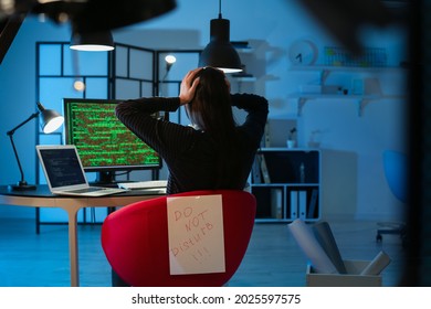 Female Programmer Working With Computer And Paper Sheet With Text DO NOT DISTURB In Office At Night