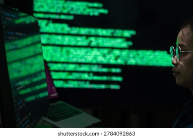 A female programmer working in a dark office environment while monitoring cybersecurity data and digital code on a computer screen. The scene represents software development, cyber technology, data analysis, and information security in a modern technology workspace.