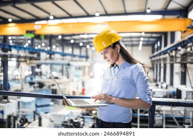 Female project manager standing in modern industrial factory. Manufacturing facility with robotics, robotic arms and automation. Storing products and materials in warehouse.