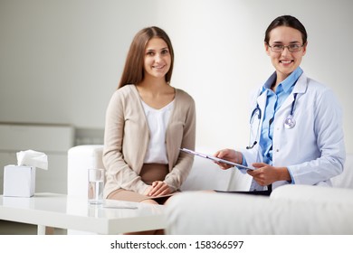 Female Psychiatrist Looking At Camera On Background Of Her Patient