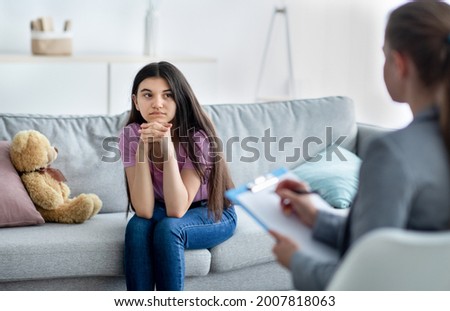 Female psychologist consulting depressed Indian teenage girl at office. Counsellor working with upset youth, helping with mental problems, treating mental disorder or neurosis at clinic