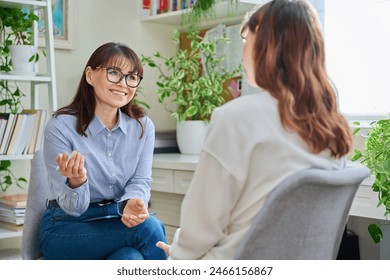 Female psychologist, counselor working with young woman, therapy in office - Powered by Shutterstock