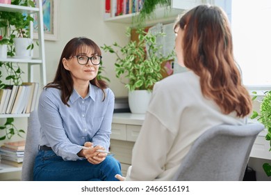 Female psychologist, counselor working with young woman, therapy in office - Powered by Shutterstock