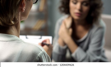 Female psychologist listening to young lady during personal session, depression