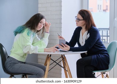 Female Psychologist Talking With Teenage Girl 15, 16 Years Old. Teenager Telling And Showing On Smartphone Problems. Mental Health Of Youth, Adolescence