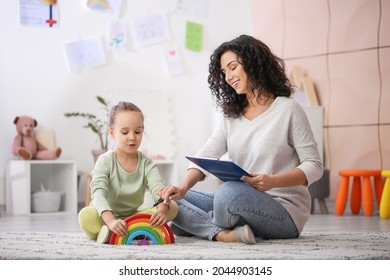 Female psychologist working with little girl at home - Shutterstock ID 2044903145