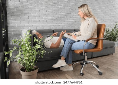 Female psychologist working with mature man during hypnosis session in office - Powered by Shutterstock