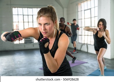 Female punching in aerobics fitness high intense fitness class coed unisex group lifestyle - Powered by Shutterstock