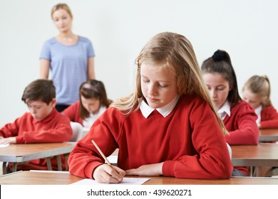 Female Pupil At Desk Taking School Exam 