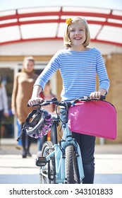 Female Pupil Pushing Bike At End Of School Day