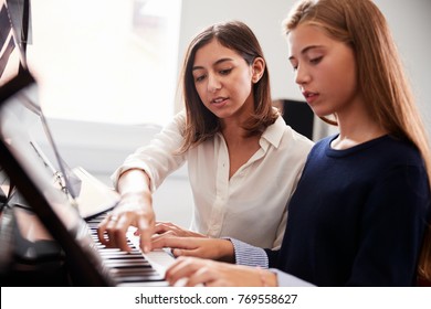 Female Pupil With Teacher Playing Piano In Music Lesson - Powered by Shutterstock