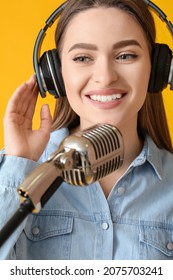 Female Radio Presenter With Microphone On Color Background