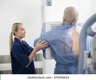 Female Radiologist Taking Chest Xray Of Mature Patient