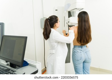 Female Radiologist And Young Woman Seen From Behind Doing A Medical Mammogram To Check For Breast Cancer