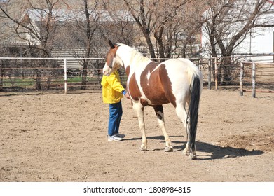 Female Rancher Bonding With Horse In Stable Outside.