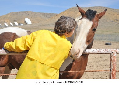 Female Rancher Bonding With Horse In Stable Outside.