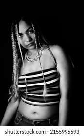 Female Rapper Wearing Braids In Front Of Black Background