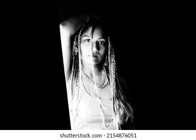 Female Rapper Wearing Braids Over Black Background