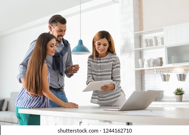 Female real estate agent working with couple, indoors - Powered by Shutterstock