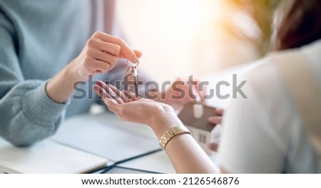 Female realestate agent giving house key to her customer, property, realestate concept.