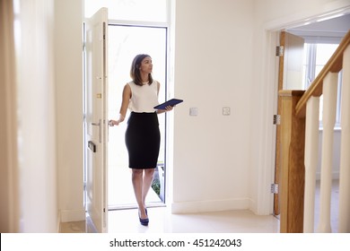 Female Realtor In Hallway Carrying Out Valuation