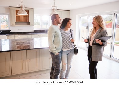 Female Realtor Showing Couple Interested In Buying Around House - Shutterstock ID 1470587294