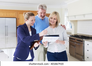 Female Realtor Showing Mature Couple Around New Home