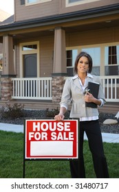 Female Realtor Standing By FOR SALE Sign