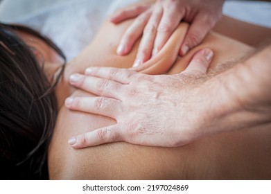 Female Receives A Back Massage In A Medical Setting From A Male Masseuse, In Spa Salon - Indoors