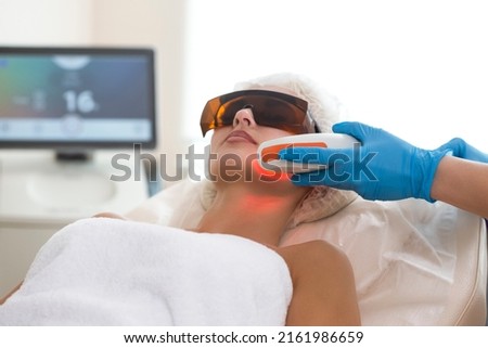 Female Receiving Facial Beauty Treatment While Removing Pigmentation in Clinic During Pulsed Laser Light Therapy or IPL Rejuvenation.Horizontal Image