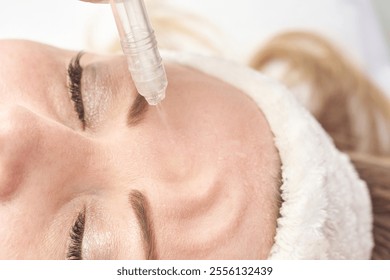 Female receiving facial treatment with microdermabrasion skincare technique in spa setting. - Powered by Shutterstock