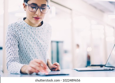 Female Receptionist Checking Notification On Digital Gadget Creating Schedule And Organizing Work,woman Administrative Manager In Eyewear Reading Income Message Standing At Clinic Near Publicity Area