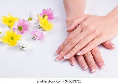 Female relaxation and care. Beautiful nails with a French manicure. Beauty salon. Spa treatments for hands. 