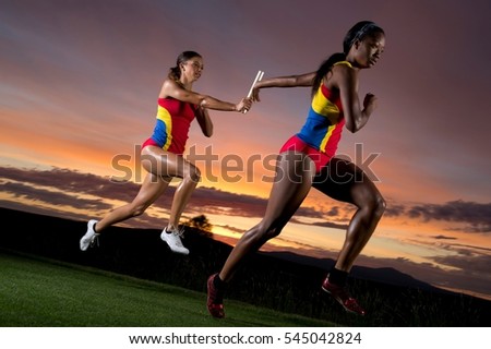Female relay racers passing baton