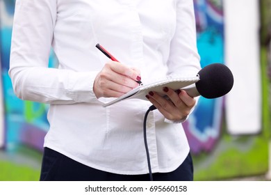 Female Reporter Taking Notes At News Conference, Writing Notes, Holding Microphone