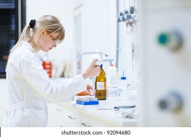 female researcher carrying out research experiments in a chemistry lab (color toned image) - Shutterstock ID 92094680