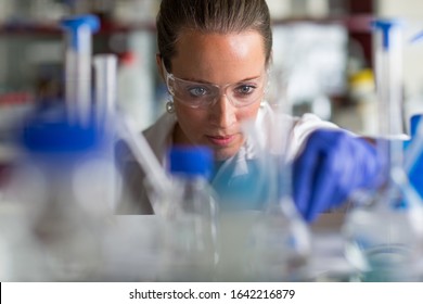 Female researcher carrying out scientific research in a lab (shallow DOF; color toned image) - Powered by Shutterstock