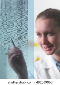 Female Researcher Examining DNA Autoradiogram Gel In Laboratory